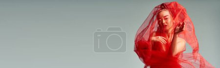 Téléchargez les photos : Femme asiatique en robe rouge et pose de voile gracieusement. - en image libre de droit