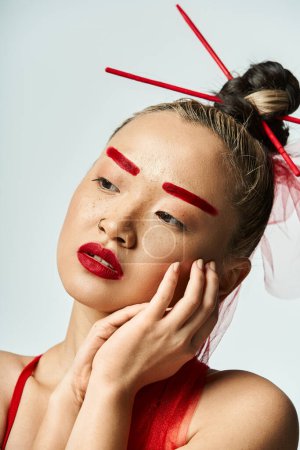 Téléchargez les photos : Une femme asiatique captivante ornée d'un maquillage rouge et d'un voile fluide. - en image libre de droit