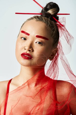 Eine Frau mit rotem Make-up und Schleier posiert dramatisch.