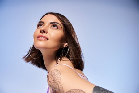 A young woman with brunette hair displaying a striking tattoo on her arm, embodying creativity and individuality.