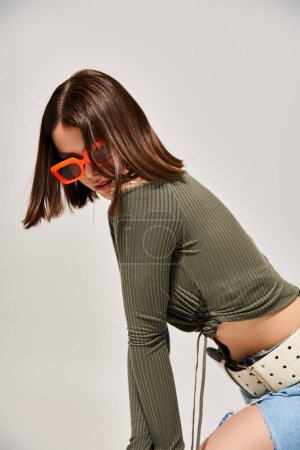 A stylish young woman with brunette hair wearing a pair of vibrant sunglasses.