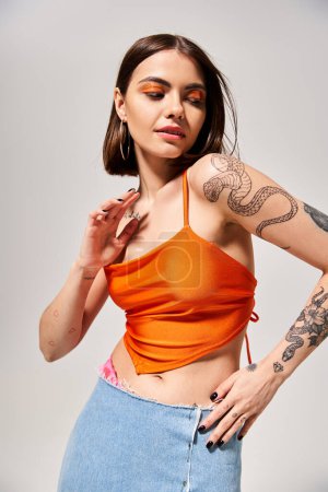 A young woman with brunette hair proudly displaying a striking tattoo on her arm in a creative studio setting.