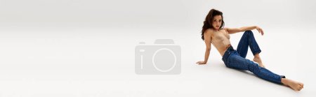 Téléchargez les photos : Une femme nue et captivante assise gracieusement sur le sol. - en image libre de droit