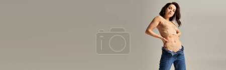 Téléchargez les photos : Une jeune femme élégante en jeans frappe une pose captivante. - en image libre de droit