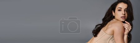 Photo for A woman in a tan dress striking a pose for a photo. - Royalty Free Image