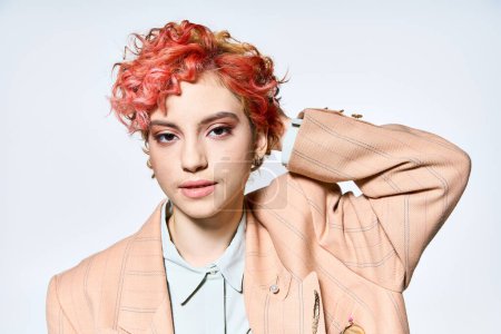 Une femme vibrante aux cheveux roux pose pour la caméra.