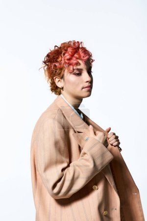 Une femme aux cheveux roux vibrante porte en toute confiance un manteau élégant.