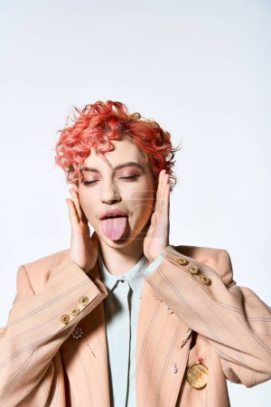 Téléchargez les photos : Une femme vibrante aux cheveux roux qui sort sa langue de façon ludique. - en image libre de droit