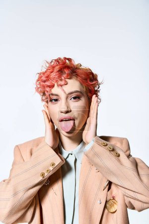 Téléchargez les photos : Une femme vibrante aux cheveux roux en tenue colorée sort sa langue de façon ludique. - en image libre de droit