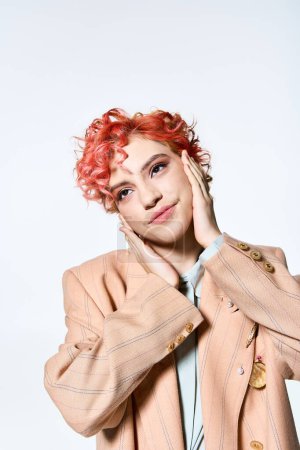 Foto de Una mujer con el pelo rojo posa con confianza en traje vibrante. - Imagen libre de derechos
