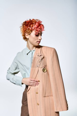 Una mujer con el pelo rojo se levanta con confianza en una chaqueta llamativa.