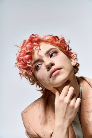 Une femme magnifique aux cheveux roux frappant une pose.