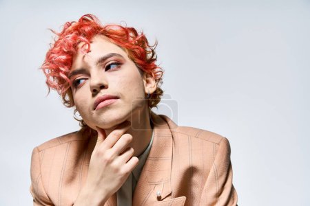 Extraordinary woman with red hair is dressed in a suit and tie.