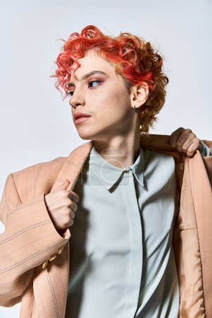 Foto de Una mujer llamativa con el pelo rojo en una chaqueta de moda. - Imagen libre de derechos