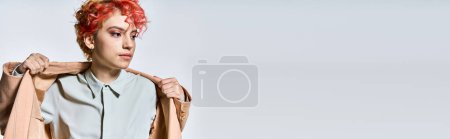 Photo for A captivating woman with red hair is stylishly dressed in a bold jacket. - Royalty Free Image