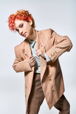 Foto de Una mujer elegante con el pelo rojo vibrante posa para una fotografía. - Imagen libre de derechos