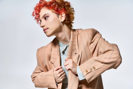 A woman with red hair wears a stylish jacket.
