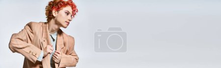 Téléchargez les photos : Une femme frappante aux cheveux roux revêtant une veste et une cravate. - en image libre de droit