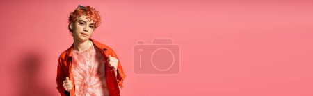 Photo for A young woman with red hair stands out in a vibrant red jacket. - Royalty Free Image