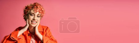 Téléchargez les photos : Femme élégante en chemise orange regardant joyeusement la caméra. - en image libre de droit