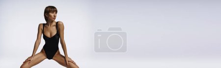 Téléchargez les photos : Une jeune femme stylée pose dans un maillot de bain noir élégant. - en image libre de droit