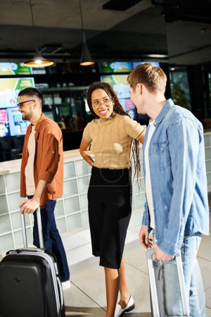 Téléchargez les photos : Groupe multiculturel de gens d'affaires en vêtements décontractés debout avec des bagages dans le hall de l'hôtel pendant le voyage d'affaires. - en image libre de droit