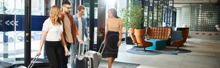 Colegas multiculturales en ropa casual se paran en el vestíbulo de un hotel con su equipaje, listos para un viaje corporativo.