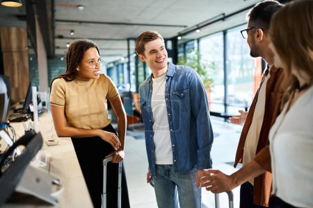 Photo for Multicultural colleagues in casual clothes standing in a circle, interacting and bonding in a hotel lobby during a corporate trip. - Royalty Free Image