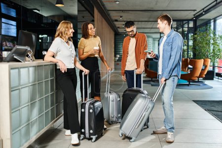 Diverse group of businesspeople in casual attire stand around with luggage in a hotel lobby, excited for their corporate trip.