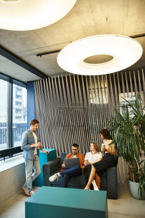 Un grupo diverso de colegas en un moderno espacio de coworking, sentados y participando en una sesión de lluvia de ideas.