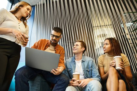 Un grupo de colegas de un equipo de startups discutiendo ideas y estrategias de negocios juntos alrededor de una computadora portátil.
