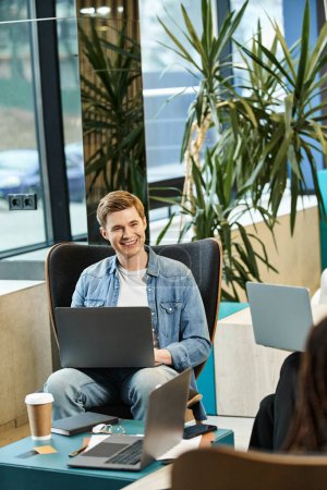 Foto de Un hombre inmerso en el trabajo, multitarea mientras está sentado en una silla, encarnando el estilo de vida empresarial moderno de un equipo de startups. - Imagen libre de derechos