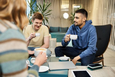 Téléchargez les photos : Collèges d'une équipe de démarrage s'engagent dans une pause café décontractée, discuter des idées et coller sur des tasses de café. - en image libre de droit