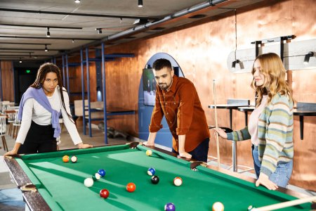 Photo for A group of startup colleagues enjoy a friendly game of pool, strategizing and bonding over shots and laughter. - Royalty Free Image