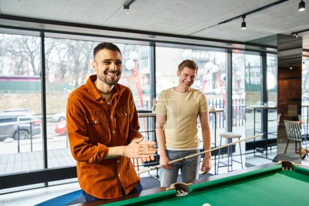 Dos hombres que diseñan estrategias y juegan al billar en un espacio de coworking, reflejando un estilo de vida empresarial moderno con un ambiente de equipo de startups.