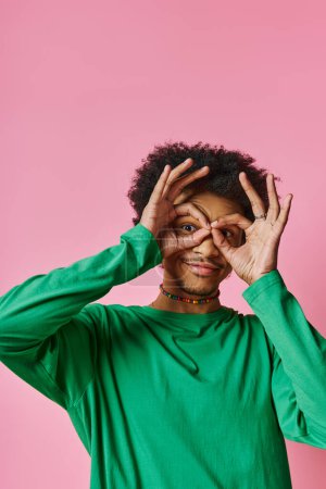african american man with curly hair covers his eyes with hands.