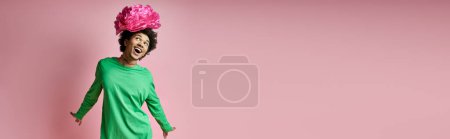Téléchargez les photos : Dark skinned man with a pink flower on her head, exudes elegance and charm. - en image libre de droit