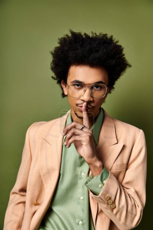 Photo for A trendy young African American man in a suit and glasses strikes a confident pose against a vibrant green backdrop. - Royalty Free Image