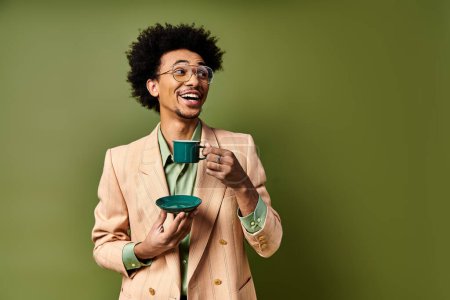 Photo for A stylish young African American man in a suit and sunglasses, holding a cup of coffee against a green background. - Royalty Free Image