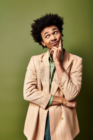 Foto de Un hombre afroamericano joven y elegante con el pelo rizado se ve sorprendido contra un fondo verde vibrante. - Imagen libre de derechos