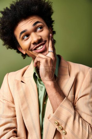 Photo for A young African American man with an afro and stylish attire poses confidently for a picture on a vibrant green background. - Royalty Free Image
