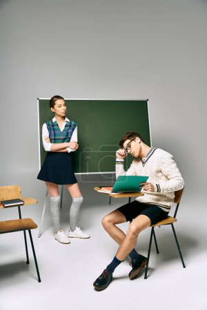 Photo for Male and female students sit elegantly in front of a green board in a college setting. - Royalty Free Image