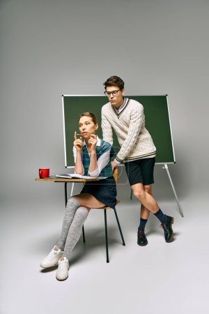 Stylish man and woman posing with elegant gestures in a college setting.