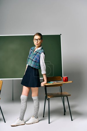 A female student in a school uniform stands confidently in front of a green board.