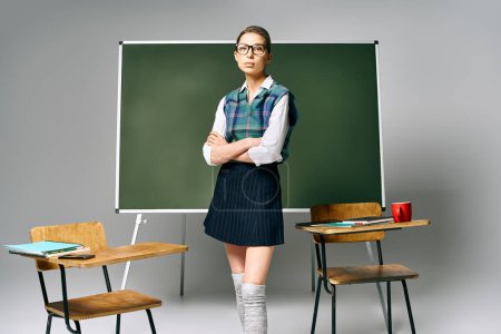 Una estudiante de uniforme se para con confianza frente a un tablero verde en un ambiente universitario.