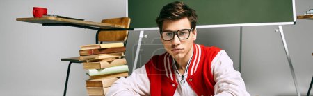 Photo for A man in glasses sitting in front of a desk. - Royalty Free Image