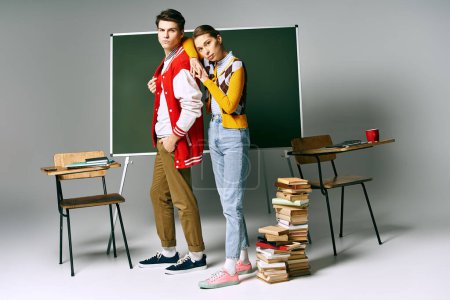 Ein Mann und eine Frau in stilvoller Kleidung posieren selbstbewusst in einem Klassenzimmer.