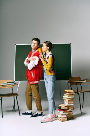 Dos estudiantes atractivos con atuendo casual de pie frente a un tablero verde en un aula universitaria.