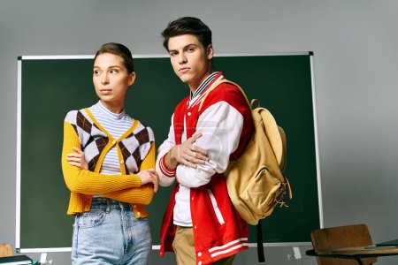Photo for Two young students in casual attire standing confidently in front of a chalkboard in a college classroom. - Royalty Free Image