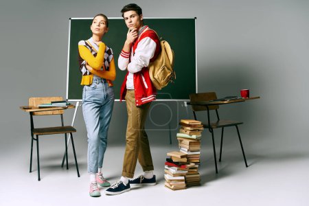 Zwei junge Studenten in Freizeitkleidung stehen vor einer grünen Tafel in einem College-Klassenzimmer.